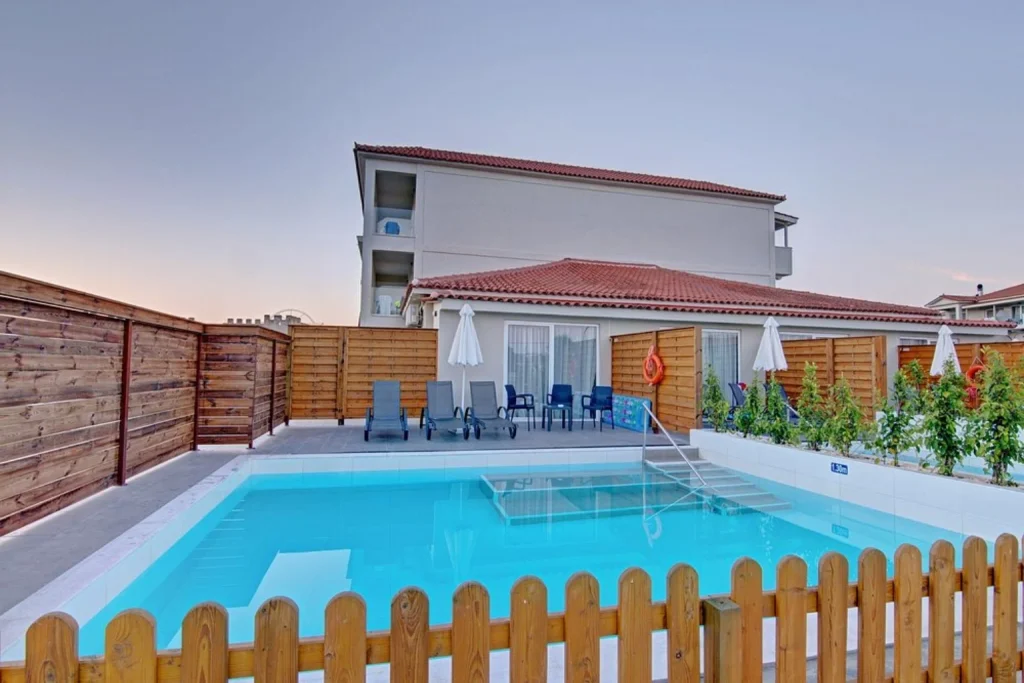 Private outdoor swimming pool with a furnished sun terrace, loungers and privacy fencing at Exotica Hotel & Spa by Zante Plaza, Zakynthos.