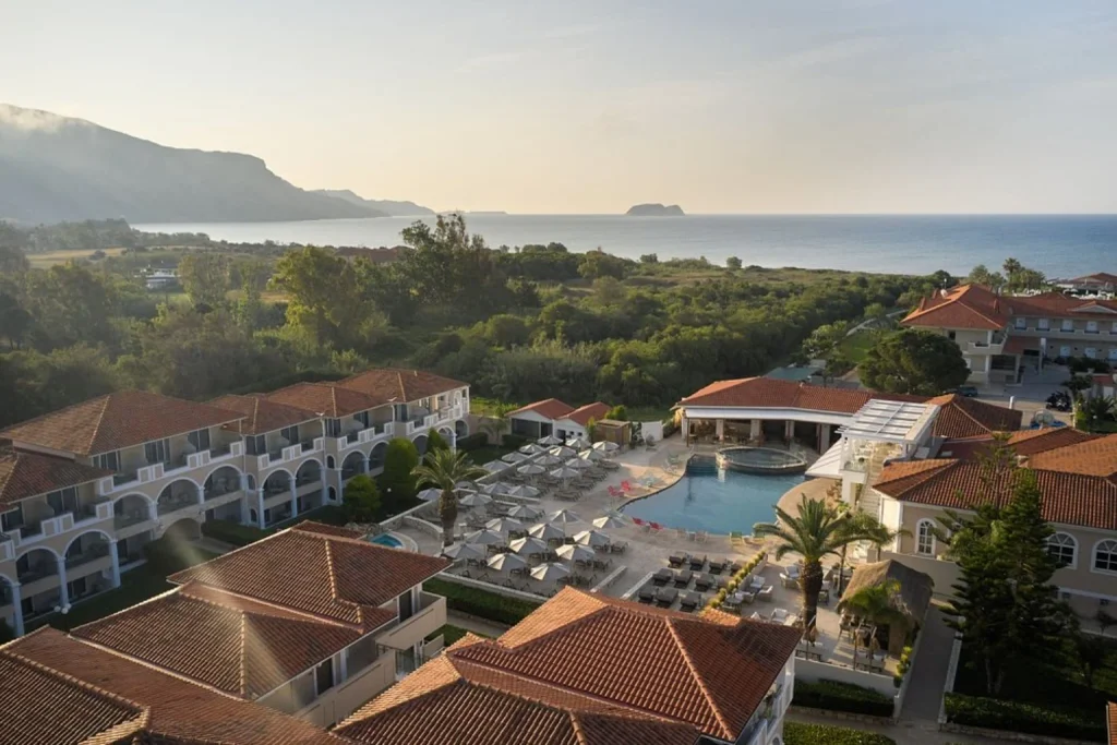 Aerial view of the resort buildings, swimming pool and Mediterranean coastline at Marelen Hotel Zakynthos, Kalamaki